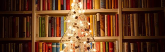 White Christmas tree in front of shelves of books.